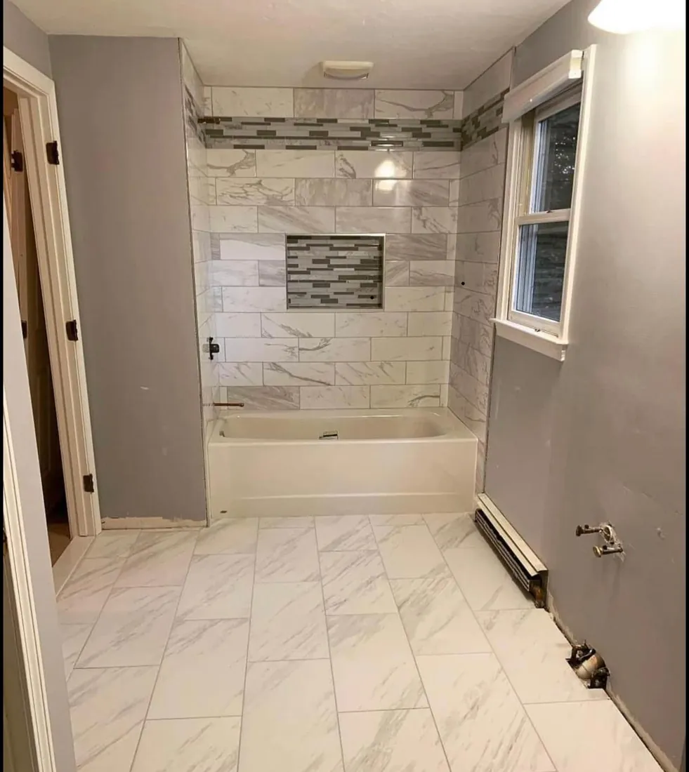 Bathroom remodel with marble-look floor and tub