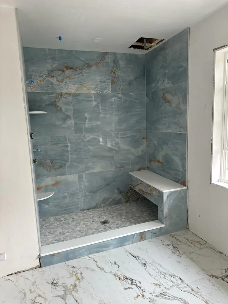 Blue marble-look porcelain shower with a tiled bench