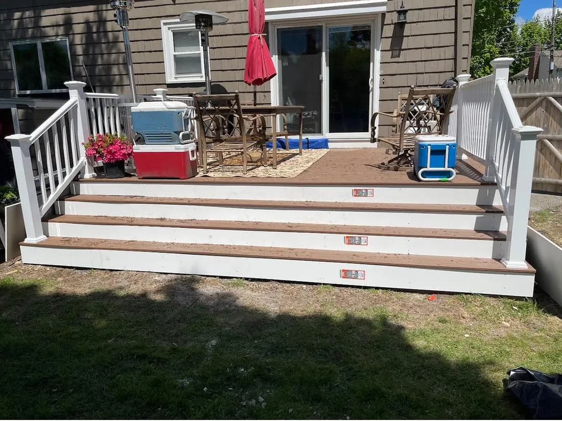 Backyard deck with white railings and wide stairs