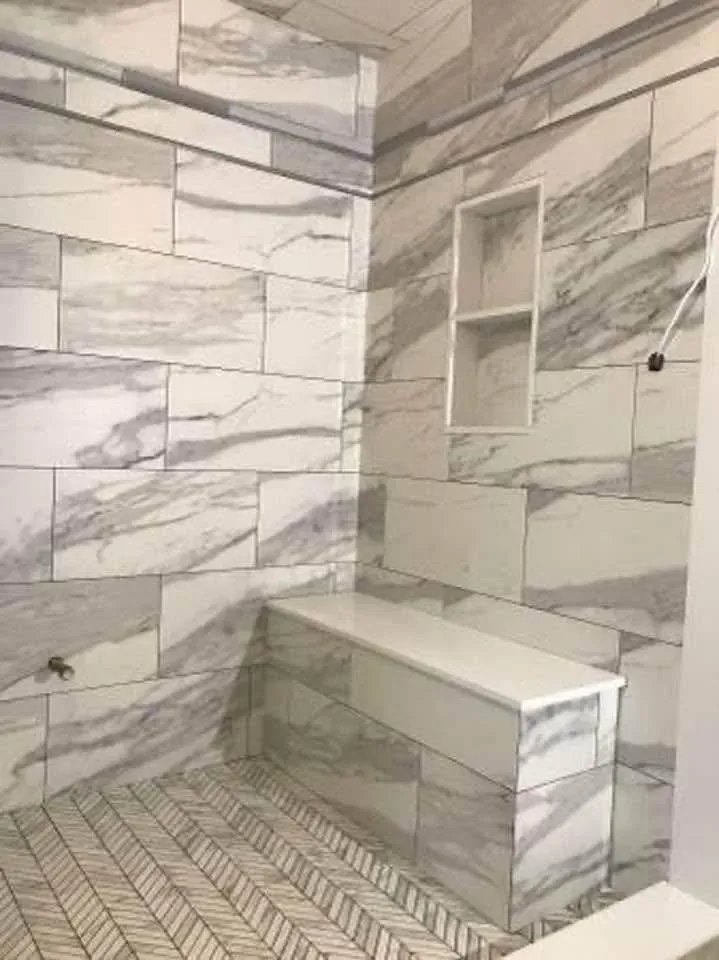 Marble-look shower bench with a herringbone floor