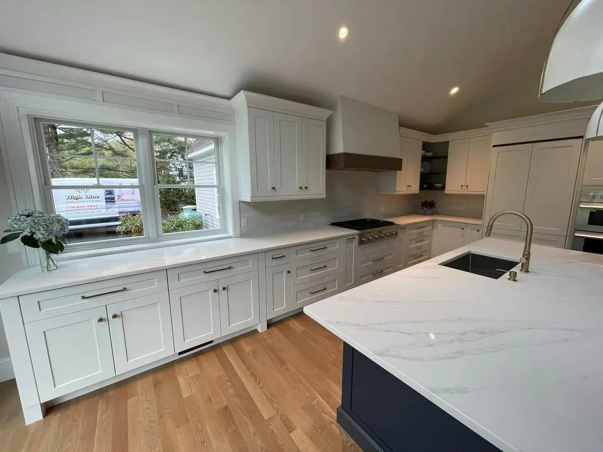Remodeled white shaker kitchen with a navy island and quartz countertops